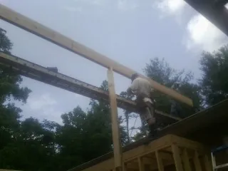 Carpenter setting a ridge beam over a new addition frame — Ice Dam Removal by Roofing Brothers in Teton