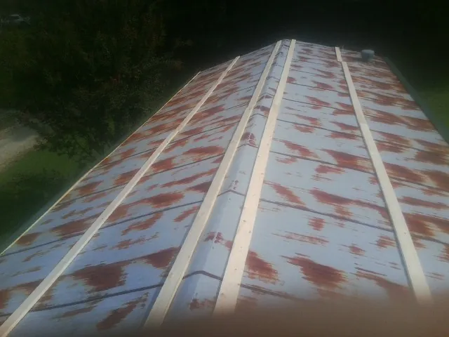 Rusted metal roof panels with new wood purlins before replacement — Storm Damage Roof Repair in Teton by Roofing Brothers