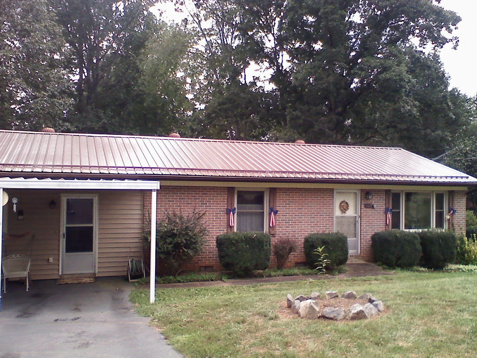 Bronze metal roof and carport on a brick ranch home — Roof Repair work by our crew in Teton